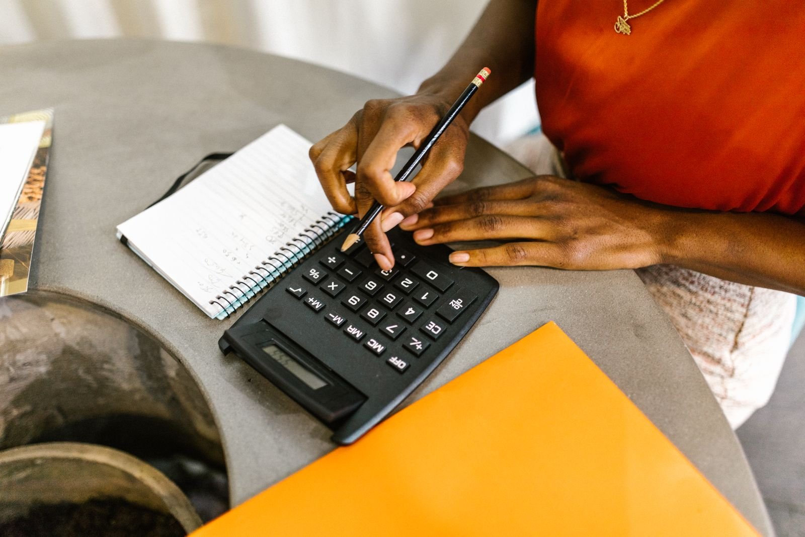 A phone calculator in use over printed reports and banknotes